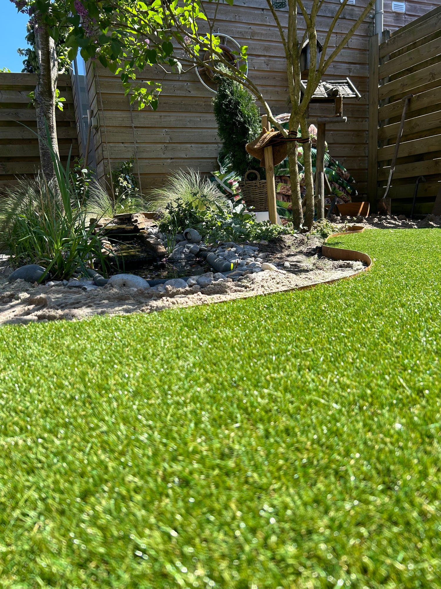 Topkwaliteit kunstgras met cortenstaal langs de plantenbak